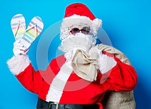 Funny Santa Claus have a fun with vacation flip flops