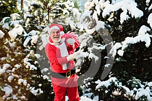 Funny Santa with Gift on Christmas Eve outside.
