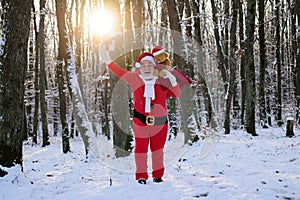 Funny Santa with Gift on Christmas Eve outside. New Year time with snow.