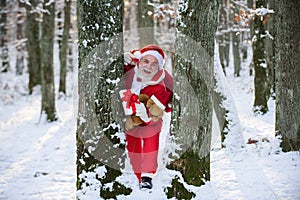 Funny Santa with Gift on Christmas winter holiday outside. Happy New Year.