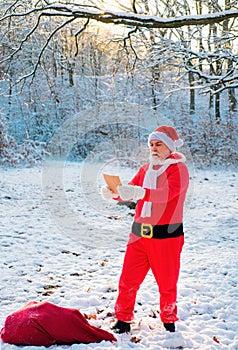 Funny Santa read wish list on Christmas Eve outside.