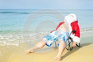 Funny Santa in shorts on the beach. Christmas in the tropics.