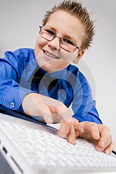 Funny school boy with laptop isolated on white