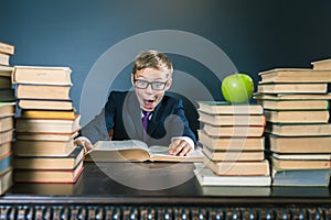 Funny school boy reading a book at library. Joke!