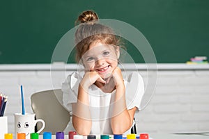Funny school girl face. Child girl drawing with coloring pens paintind. Portrait of adorable little girl smiling happily