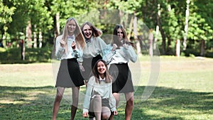 Funny schoolgirls posing and goofing around in a meadow.