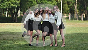 Funny schoolgirls posing and goofing around in a meadow.