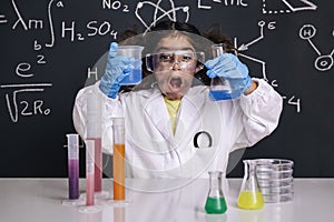 Funny scientist child with goggles in lab coat