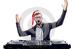 Funny screaming guy dj in Santa's hat, glasses plays music on a turntable raises hands up. studio shot