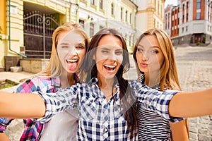 Funny selfie of three girlfriends pouting and showing tongue