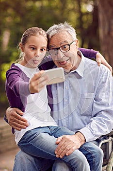 Funny selfie time- granddaughter and disabled man in wheelchair