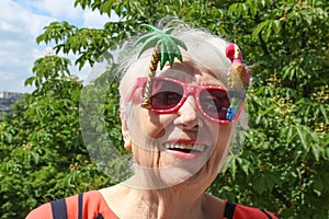 Funny senior woman against summer background