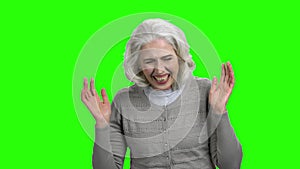 Funny senior woman is laughing on green screen.