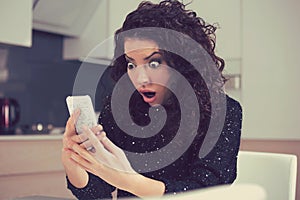 Funny shocked anxious woman looking at phone seeing bad photos message