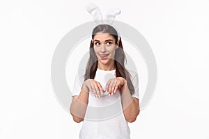 Funny and silly, playful girl in rabbit ears, t-shirt, looking away and licking lips, daydreaming about something