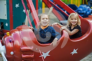 Funny sisters on carousel ride