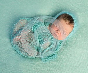 Funny sleeping newborn on blue blanket and in diaper
