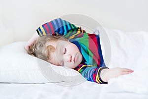 Funny sleeping toddler girl in a white bed photo