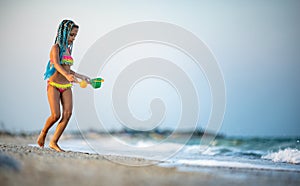 Girl playing with waves kicking and spinning under the summer sun enjoying the vacation