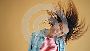 Funny slow motion portrait of joyful girl moving head waving hair laughing