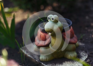 Funny smiling ceramic turtle in the garden