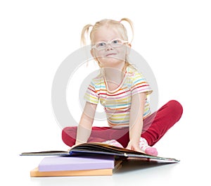 Funny smiling child in eyeglases reading book