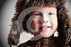 Funny smiling child in a fur hat. fashion kid. winter style. little boy. children