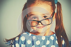Funny smiling child girl in glasses