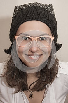 Funny smiling girl portrait with winter hat and summer glasses