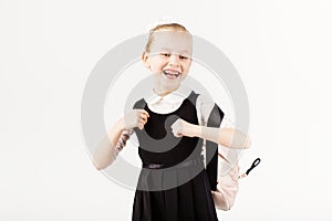 Funny smiling little girl with big backpack jumping and having f