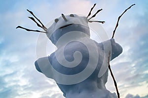 Funny snowman on a background of cloudy sky