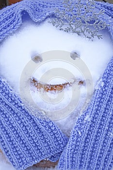 Funny snowman for New year 2021. New year`s pumpkin snowman in a hand-knitted lilac scarf