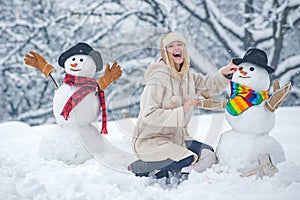 Funny snowmen. Happy smiling girl make snowman on sunny winter day. People in snow. Snowman. Beauty Winter Girl with