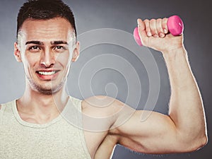 Funny sporty fit man lifting light dumbbell. Fun.