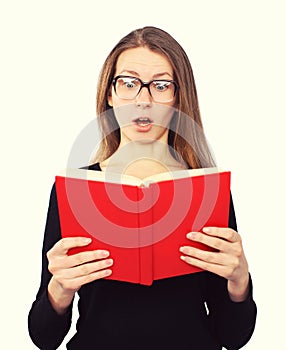 Funny student girl in glasses shocked looking in the book