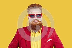 Funny stylish extravagant bearded chubby man pretending to be serious on vivid yellow background.