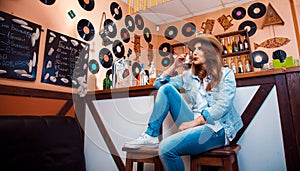 funny stylish girl in the bar drinking a cocktail through a straw