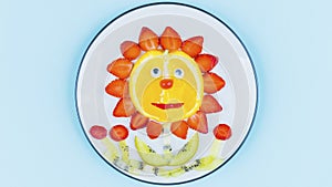 Funny sunflower face made of fresh fruits on plate