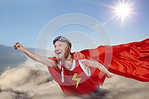 A funny super hero fly above the clouds in the sky