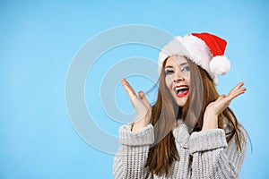 Funny surprised woman in Christmas Santa hat