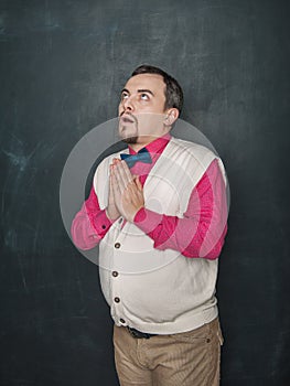 Funny teacher or business man pray on blackboard