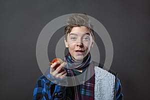 Funny teenage boy holding an apple