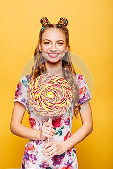 Funny teenage girl holdss big lollipop