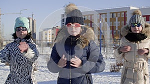 Funny teenager girl in goggles swimming outdoor on winter urban landscape. Playful girl teenager showing dance flash mob