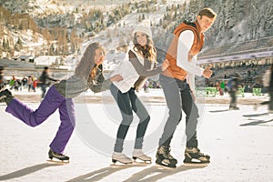 Funny teenagers girls and boy skating outdoor, ice rink