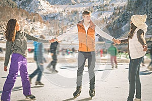 Funny teenagers girls and boy skating outdoor, ice rink