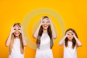 Funny three sister ladies holding hands in okey symbols near eyes like specs wear casual outfit isolated yellow