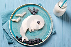 Funny toast in a shape of whale, sandwich with cream cheese and blueberries, food for kids idea, top view