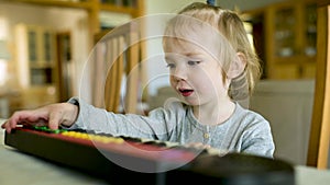 Funny toddler boy playing toy piano at home