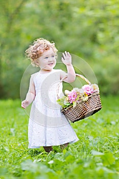 Funny toddler girl playing with a flower basket